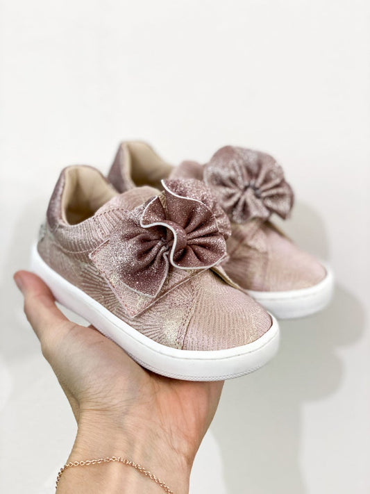 Sneakers in tessuto rosa con decorazione fiore e velcro regolabile. Una scarpa chiusa confortevole con un delicato dettaglio centrale che la rende fine e adatta a tutti i tipi di abbigliamento. Consigliata su abiti fashion o per dare un tocco di originalità ad abiti eleganti.